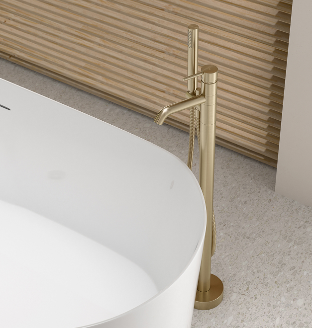 Nowoczesna bateria łazienkowa CIRICULUS w kolorze złotym, zamontowana przy wannie wolnostojącej.